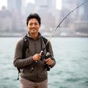 Dolon Amorim standing on a city shoreline holding a telescopic rod